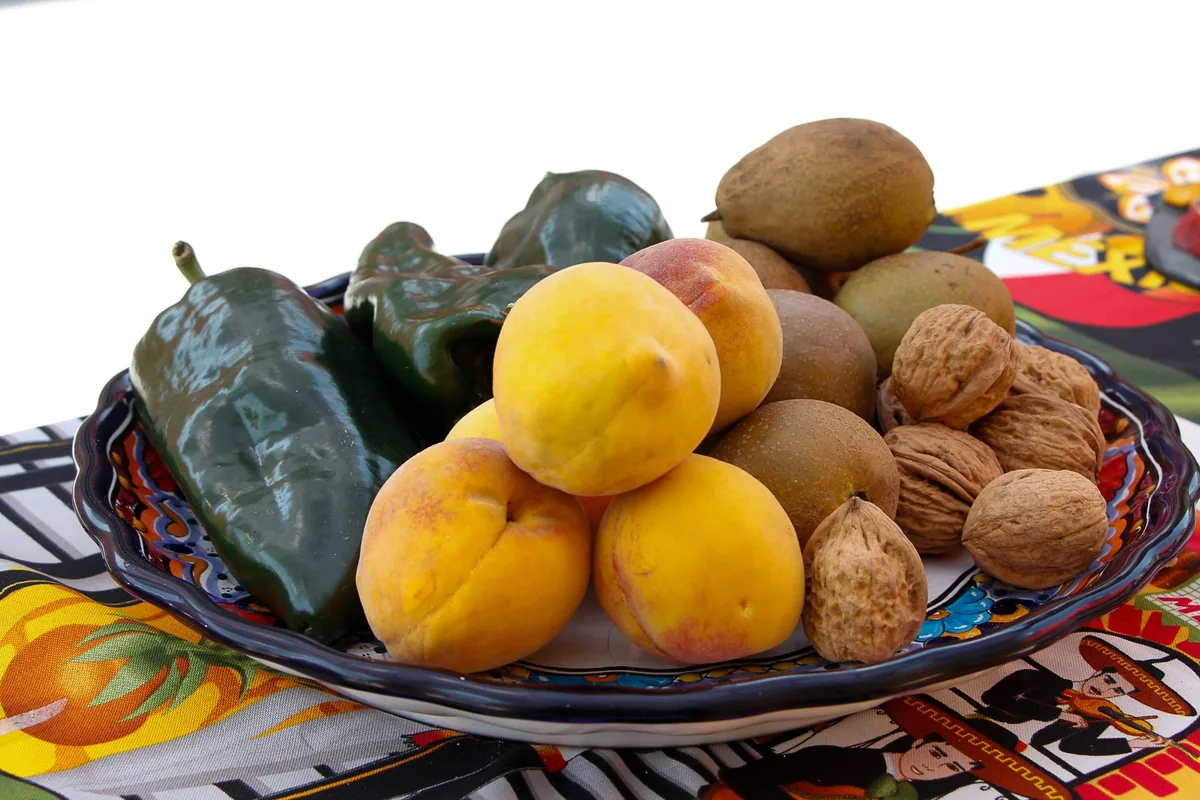 Los ingredientes de origen —chile poblano, nuez de Castilla, manzana panochera— y la fachada plateresca del siglo XVI del Ex Convento de San Francisco, en Calpan.